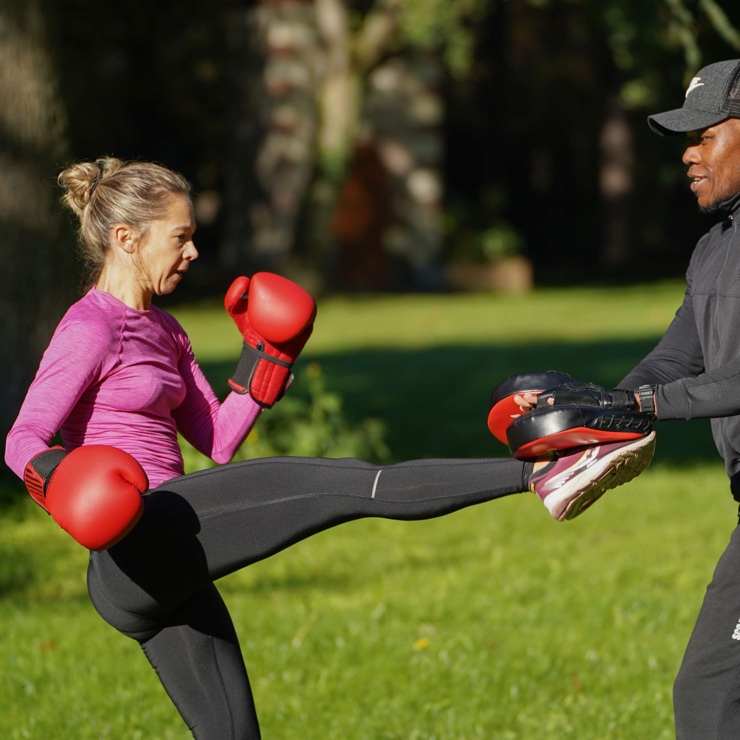 ElieB Coaching, coach sportif à Angers, en train d'entraîner une femme en plein air à la boxe, avec des pads